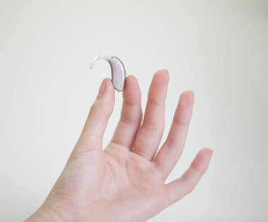 Kadınların elindeki işitme cihazı çok küçük.