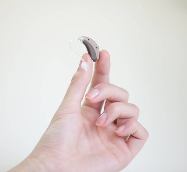Kadınların elindeki işitme cihazı çok küçük.