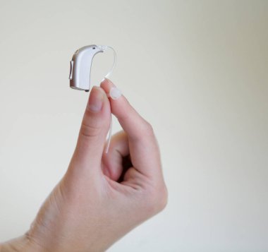 Bir kadının elinde çok küçük bir işitme cihazı