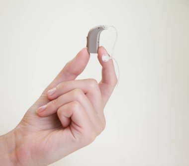 Bir kadının elinde çok küçük bir işitme cihazı