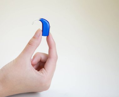 Bir kadının elinde çok küçük bir işitme cihazı