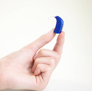 Bir kadının elinde çok küçük bir işitme cihazı