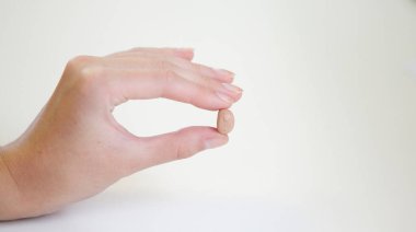 Bir kadının elinde çok küçük bir işitme cihazı