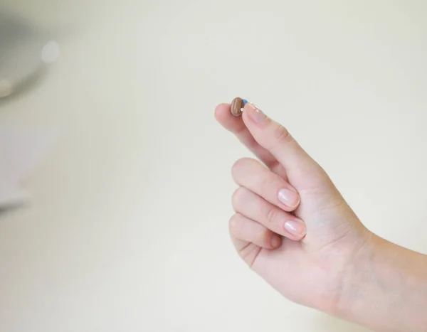 Bir Kadının Elinde Çok Küçük Bir Işitme Cihazı — Stok fotoğraf