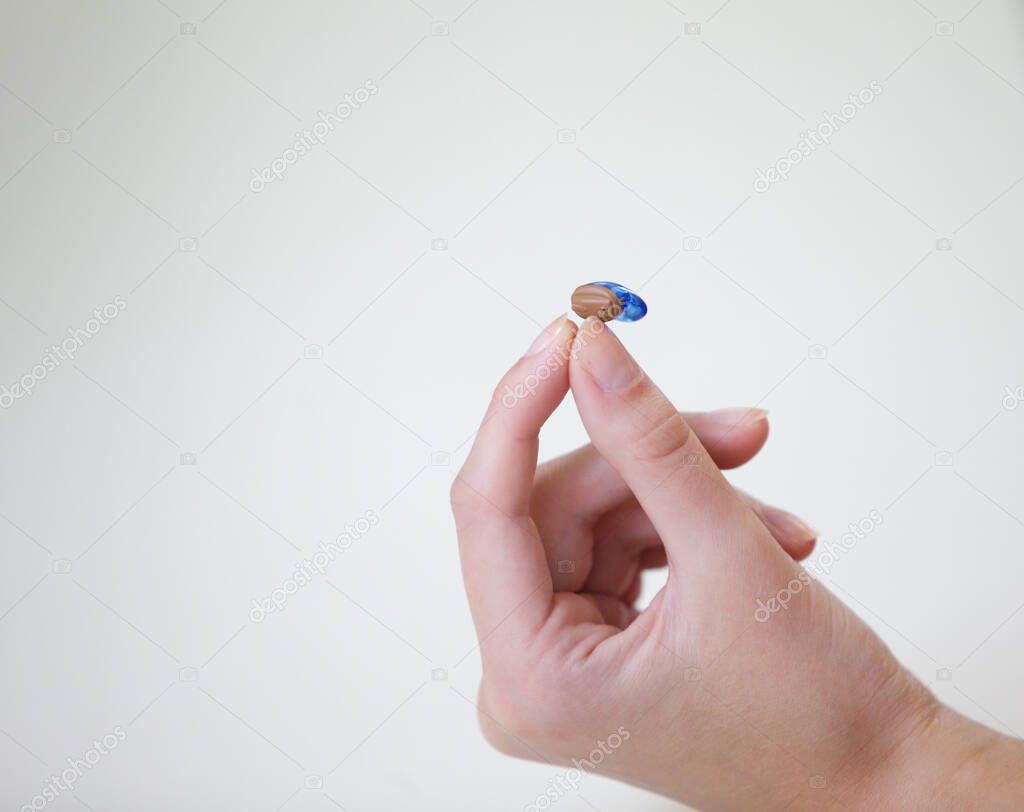 Very small hearing aid in a female hand