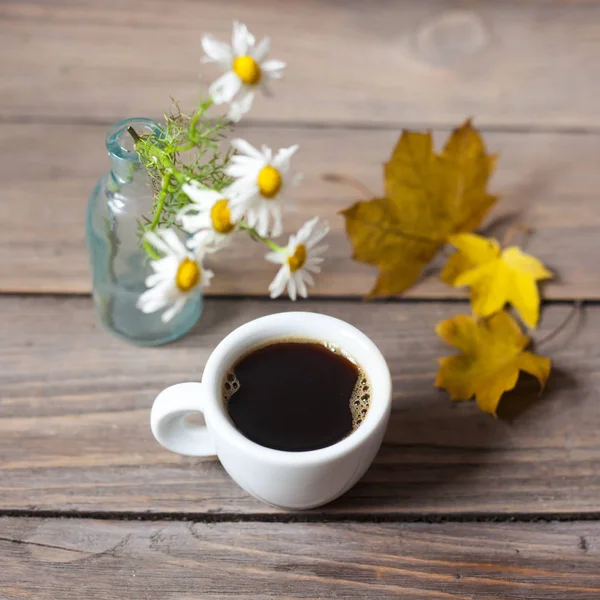 Coffee with chamomiles and autumn leaves — Stock Photo, Image