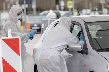 Vilnius, Litvanya, 19 Mart 2020. Koruyucu ekipman tıbbi personeli, Litvanya 'nın Vilnius kentindeki açık hava mobil test merkezinde COVID-19 Coronavirus için örnek topluyor..