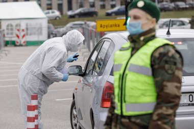 Vilnius, Litvanya, 19 Mart 2020. Koruyucu ekipman tıbbi personeli, Litvanya 'nın Vilnius kentindeki açık hava mobil test merkezinde COVID-19 Coronavirus için örnek topluyor..