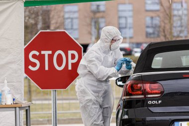 Vilnius, Litvanya, 19 Mart 2020. Koruyucu ekipman tıbbi personeli, Litvanya 'nın Vilnius kentindeki açık hava mobil test merkezinde COVID-19 Coronavirus için örnek topluyor..