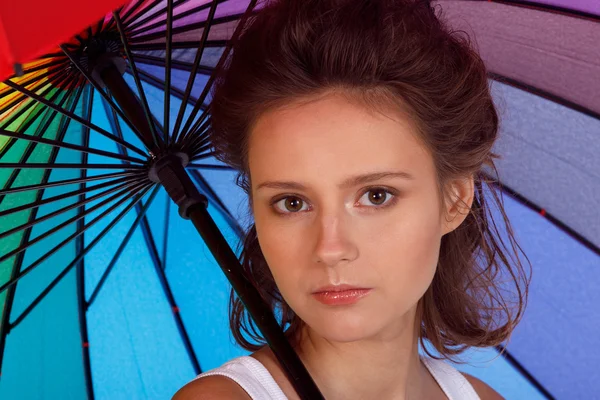 Sonriente joven morena en blusa blanca con paraguas de color — Foto de Stock