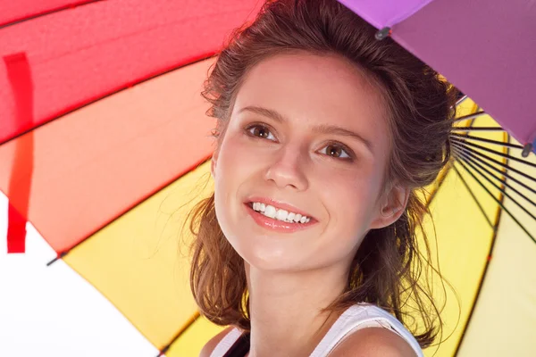 Sorrindo jovem morena de blusa branca com guarda-chuva de cor — Fotografia de Stock
