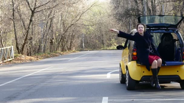 Жінка чекає допомоги біля brocken автомобілем на лісовій дорозі — стокове відео