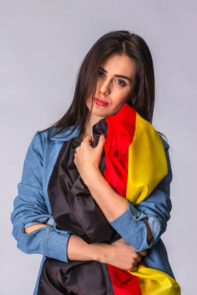 Deutschland-Fahne in den Händen einer traurigen schönen Frau. — Stockfoto