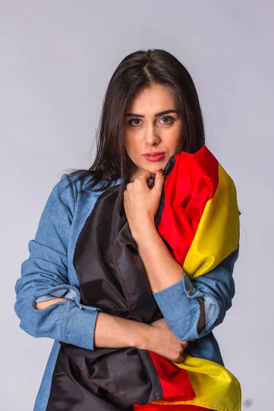 Deutschland-Fahne in den Händen einer traurigen schönen Frau. — Stockfoto