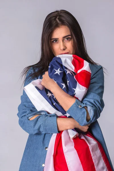 Bandera de Estados Unidos de América en manos de una mujer hermosa y triste — Foto de Stock