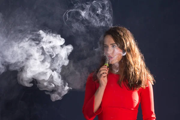 Žena kouření elektronická cigareta na modré poza — Stock fotografie