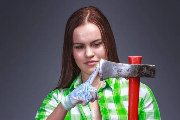 Woman checks how acutely sharpened ax — Stock Photo, Image