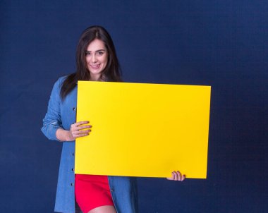 Sarı boş kağıdın, mavi arka plan üzerinde tutan mutlu kadın