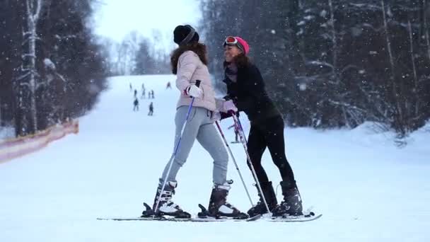 Gemelos jóvenes con estación de esquí en la colina — Vídeo de stock