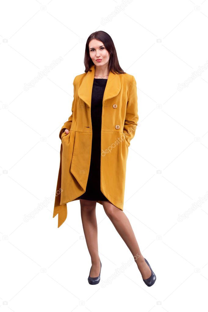 Portrait of fashion girl in yellow coat  posing on light backgro