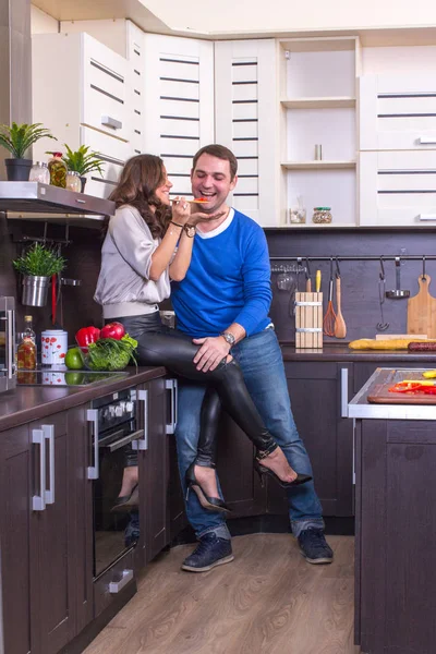 Retrato de casal amoroso com comida na cozinha — Fotografia de Stock