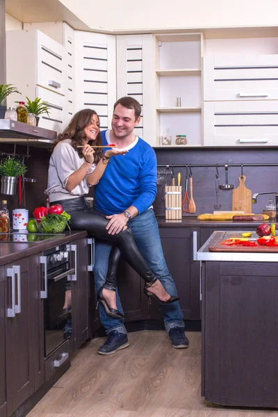 Retrato de casal amoroso com comida na cozinha — Fotografia de Stock