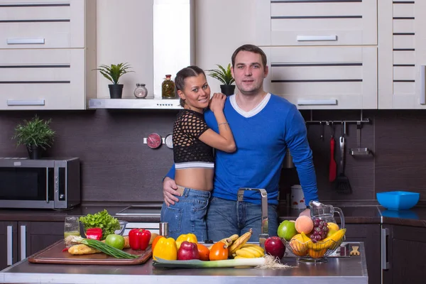 Jovem casal feliz na cozinha fazendo salada orgânica . — Fotografia de Stock