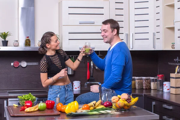 Genç mutlu çift mutfakta organik salata çatalı.