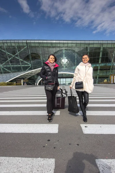 Schöne Frauen auf Reisen - zu Fuß mit Gepäck am Flughafenauto — Stockfoto