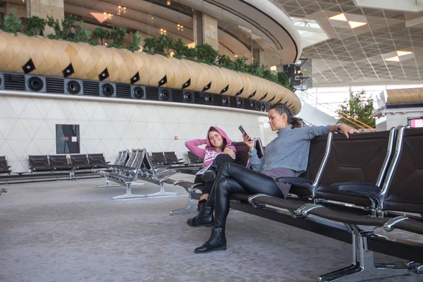 Mulher gêmea sentada no lounge do aeroporto — Fotografia de Stock