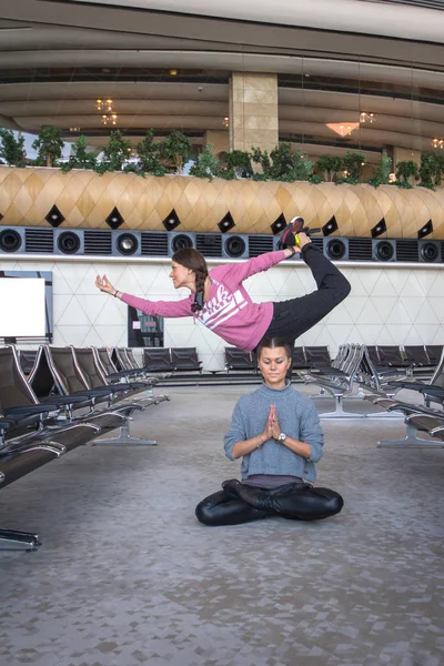 Mujer haciendo yoga en la sala del aeropuerto — Foto de Stock