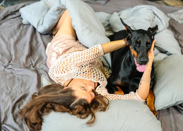 Mulher na cama com cachorro grande — Fotografia de Stock