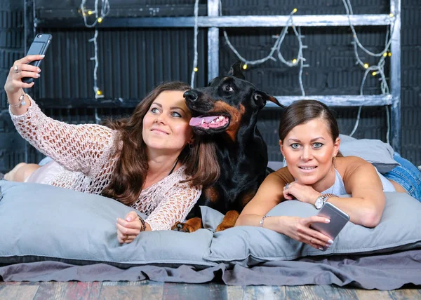 Twins doen selfie in bed met grote hond — Stockfoto