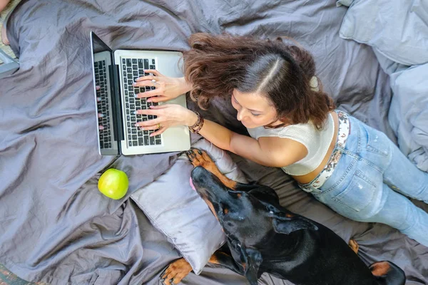 Mulher na cama com cachorro grande — Fotografia de Stock