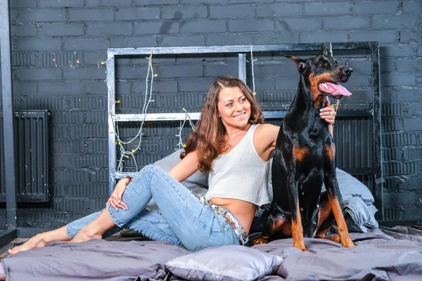 Женщина в постели с большой собакой — стоковое фото