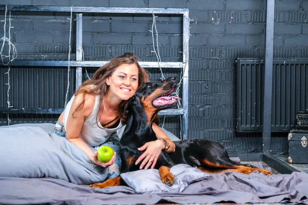 Γυναίκα στο κρεβάτι με μεγάλο σκύλο — Φωτογραφία Αρχείου