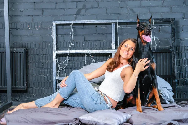Mujer en la cama con perro grande — Foto de Stock