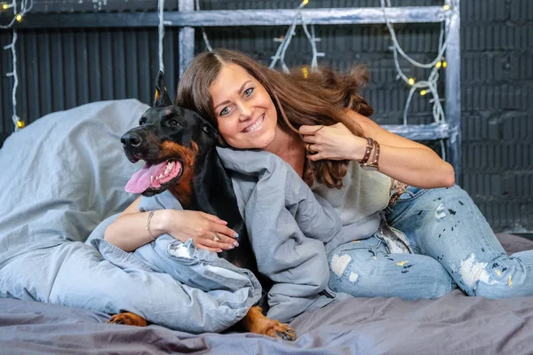 Mujer en la cama con perro grande —  Fotos de Stock