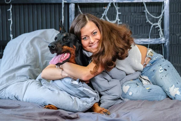 Kvinna i säng med stor hund — Stockfoto