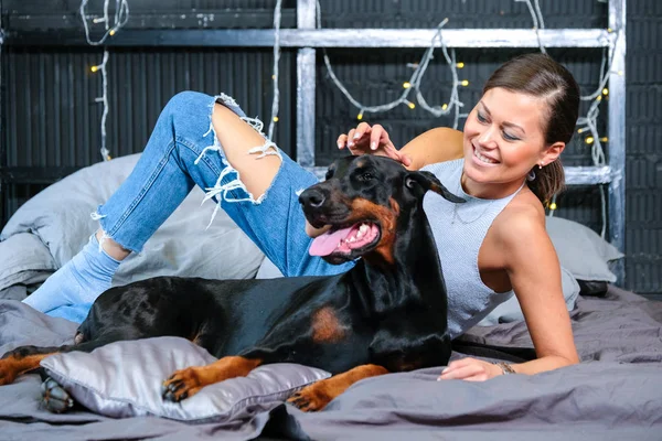 Žena v posteli s velkým psem — Stock fotografie