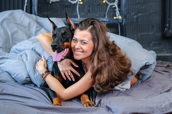 Mulher na cama com cachorro grande — Fotografia de Stock