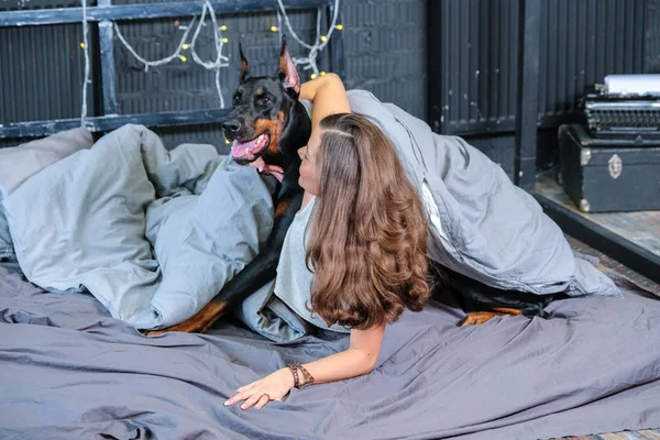 Frau im Bett mit großem Hund — Stockfoto