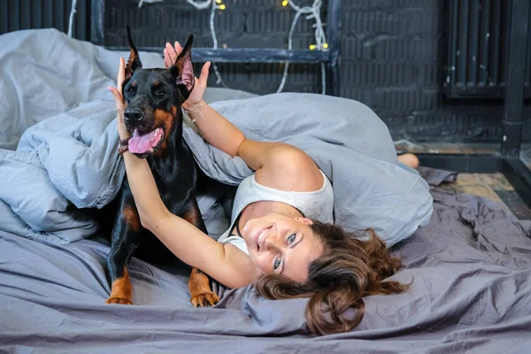 Büyük köpek ile yatakta kadın — Stok fotoğraf