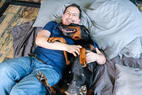 Hombre en la cama con perro grande — Foto de Stock