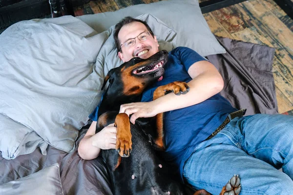 Hombre en la cama con perro grande — Foto de Stock