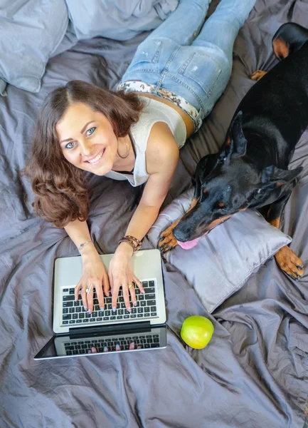 Frau im Bett mit großem Hund — Stockfoto