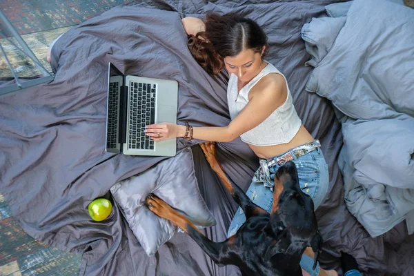 Frau im Bett mit großem Hund — Stockfoto