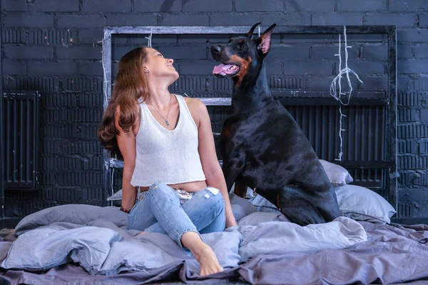 Γυναίκα στο κρεβάτι με μεγάλο σκύλο — Φωτογραφία Αρχείου