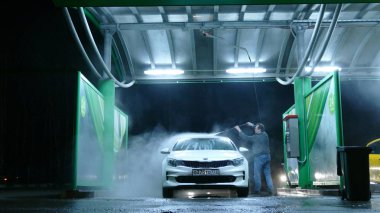 Gece, zaman atlamalı el ile araba yıkamacıda adam