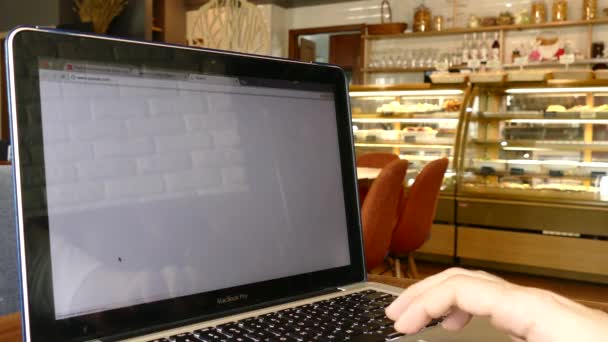 Mann erkunden Raum x Website auf Laptop-Bildschirm im Café — Stockvideo